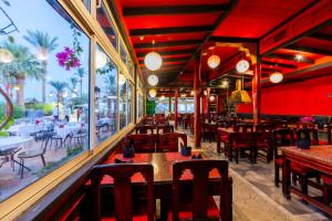 沙姆沙伊赫Ghazala Beach的餐厅拥有红色的墙壁和桌椅
