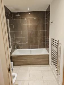 克罗伊登Santina Apartments的带浴缸和卫生间的浴室。