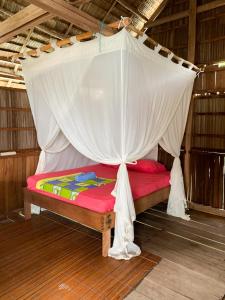 KriGibran guest house的一张带天蓬的床