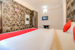 巴特那OYO Flagship 78696 Hotel Kamini的卧室配有带红色枕头的大型白色床