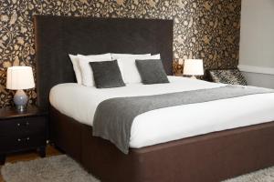 MaresfieldChequers Inn by Greene King Inns的卧室配有一张带白色床单和枕头的大床。