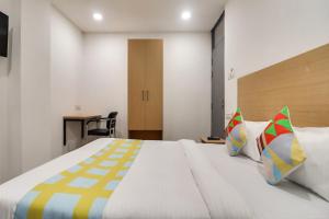 HasanganjOYO Home Basera Homes的一间卧室配有一张带色彩缤纷枕头的大床