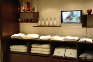 和歌山和歌山格兰比亚大酒店的一间设有书架、白色毛巾和电视的客房