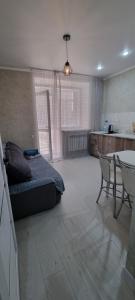 科克舍套Однокомнатная квартира в районе ЖК Аружан的卧室配有一张床和一张桌子及椅子
