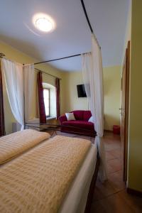 VitovljeFarm Stay Malovščevo的一间卧室配有两张床和一张红色沙发
