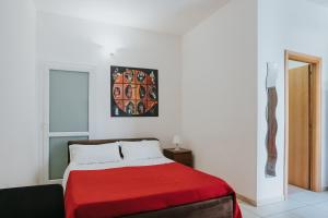 莱切B&B Nuovo Reale - CENTRO STORICO的一间卧室配有一张带红色毯子的床