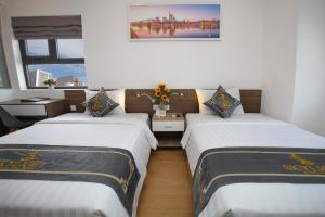 芽庄Skylight Hotel Nha Trang的带2扇窗户的客房内的2张床