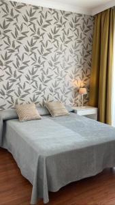 托雷德尔马尔Las Américas - Mares的一间卧室配有一张带花卉壁纸的大床