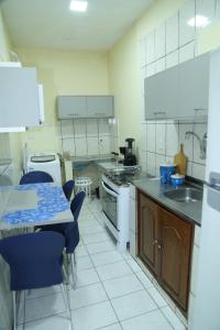马拉巴Apartamento excelente Marabá的厨房配有桌子和蓝色椅子