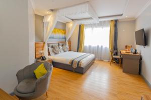 Raha Suites - Westlands的配有一张床和一把椅子的酒店客房