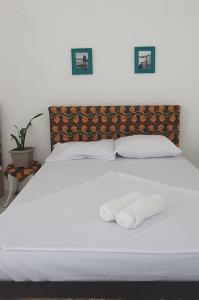 萨尔瓦多Terraço Ribeira Casa p Temporada的一张白色的床,上面有两条毛巾