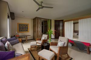 乌布巴厘岛豪华别墅式酒店的客厅配有沙发、椅子和吊扇