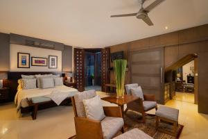 乌布巴厘岛豪华别墅式酒店的卧室配有一张床和一张桌子及椅子