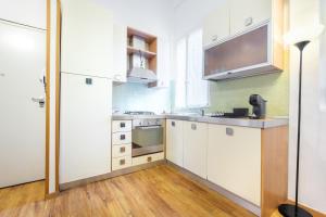皮昂比诺Green Coast House 5的厨房配有白色橱柜和炉灶烤箱。