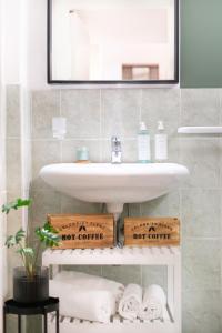 皮昂比诺Green Coast House 5的浴室配有盥洗盆、镜子和毛巾