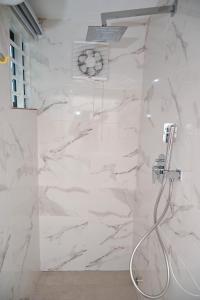 阿克拉Lokko Serene的一间设有白色大理石墙壁和淋浴的浴室