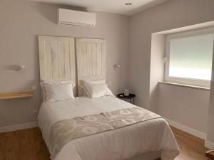 塞亚Casa do Bairro的卧室配有一张大白色床和窗户
