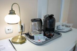 苏恰瓦爱丽丝旅馆的台灯旁的桌子上装有咖啡壶的托盘