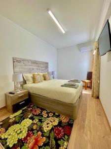 维拉维索萨APART Casas Brancas的一间卧室配有一张床和一台电视