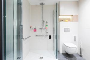 德累斯顿Moxy Dresden Neustadt的带淋浴和卫生间的白色浴室