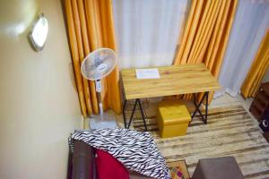 基苏木Casabella Apartment - Pristine Homes,Tom Mboya的客房配有书桌、风扇和窗帘