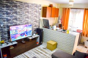 基苏木Casabella Apartment - Pristine Homes,Tom Mboya的一间带电视和砖墙的客厅