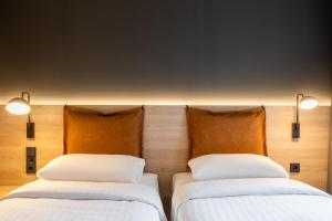 德累斯顿Moxy Dresden Neustadt的两张睡床彼此相邻,位于一个房间里