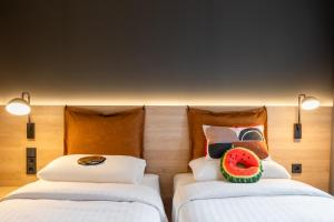 德累斯顿Moxy Dresden Neustadt的客房设有两张床,枕头上配有西瓜