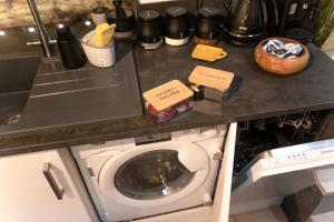 弗罗姆Luxury Bumblebee Cottage Frome Longleat Aqua Sana Bath DOG FREEndly的厨房里配有带洗衣机的厨房台面