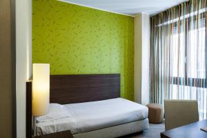 米兰德斯艾特昂格尔斯酒店的一间卧室设有一张床和绿色的墙壁
