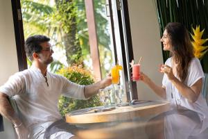乌布巴厘岛豪华别墅式酒店的坐在桌子上喝饮料的男人和女人
