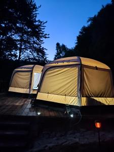 罗斯诺夫·波德·拉德霍斯滕Glamping Rožnov的两个帐篷在晚上停在停车场