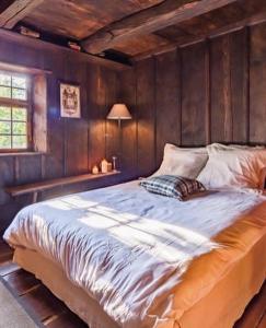 Rangen玛丽农场度假屋的卧室设有一张大床,卧室设有木墙