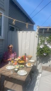 格里姆斯塔Sørlandsidyll nær by og Dyreparken的坐在桌子上,吃着食物的女人