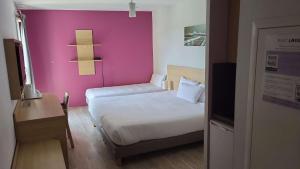 圣普列斯特里昂东欧洲博览馆东方住宿酒店的一间小卧室,配有粉红色的墙壁和一张床