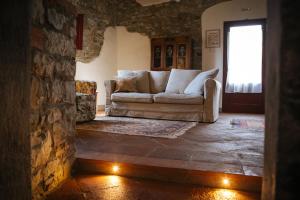 拉达-因基安蒂Podere Terreno alla via della volpaia的带沙发和石墙的客厅