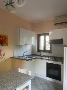 PianellaCasa Adalgisa的厨房配有白色橱柜和台面