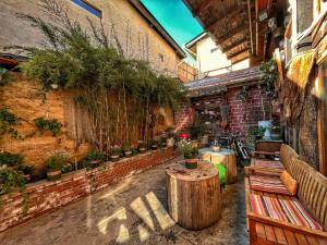香格里拉Tavern Hostel仁和客栈的砖墙上种有长椅和盆栽植物的庭院