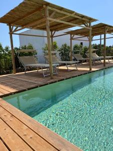 帕图Volito Rural Experience的一个带木制甲板和凉亭的游泳池