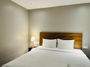 吉隆坡The Bed Bukit Bintang的卧室配有一张白色大床和木制床头板