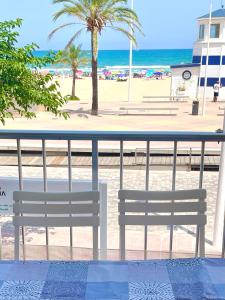 甘迪亚海滩Apartamento TalaMar Gandia Playa的海滩前的两把长椅