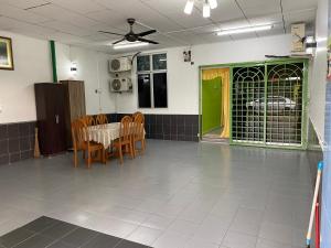 马六甲83 Homestay的配有桌椅和绿门的房间