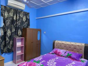 马六甲83 Homestay的一间卧室配有一张床和一个小橱柜