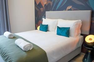 法鲁Guest House Jacarandá Faro的一间卧室配有两张带蓝色枕头的床