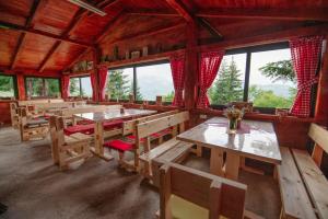 科拉欣Komovi - Kobil Do Guesthouse的用餐室设有木桌、长凳和窗户。