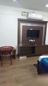 海得拉巴Hitech Shilparamam Guest House的客厅配有电视和椅子