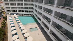 圣地亚哥港罗格斯凯萨蓝海酒店的享有带游泳池和遮阳伞的建筑的空中景致