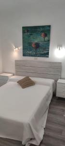 帕尔斯Chalet Sol y Sombra的卧室配有一张白色床,墙上挂有绘画作品
