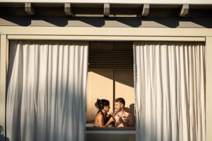 维泰博Alla Corte Delle Terme Resort的男人和女人在窗口里看着