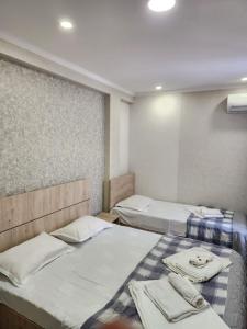 第比利斯Tbilisi Center Hotel的一间设有三张床的客房,备有毛巾